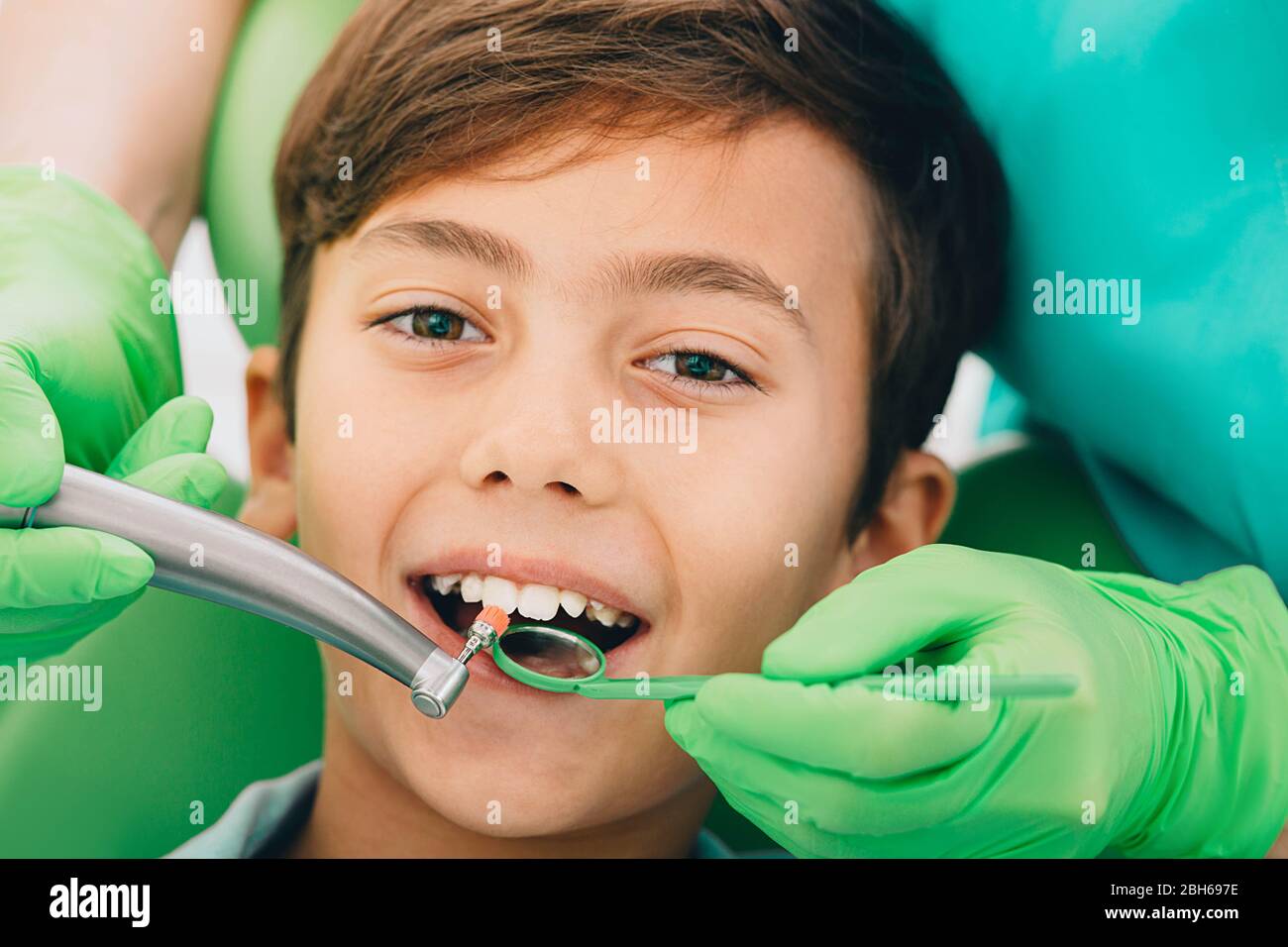 Piccolo ragazzo carino mentre il trattamento dei denti. Pulizia della placca, primo piano. Odontoiatria per bambini Foto Stock
