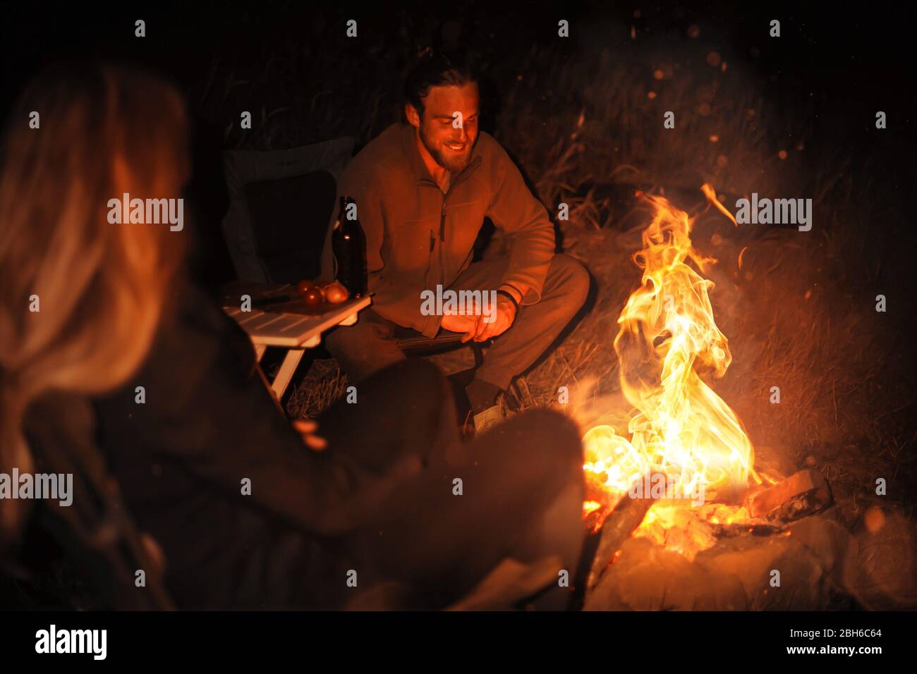 Due persone intorno a un fuoco di notte Foto Stock
