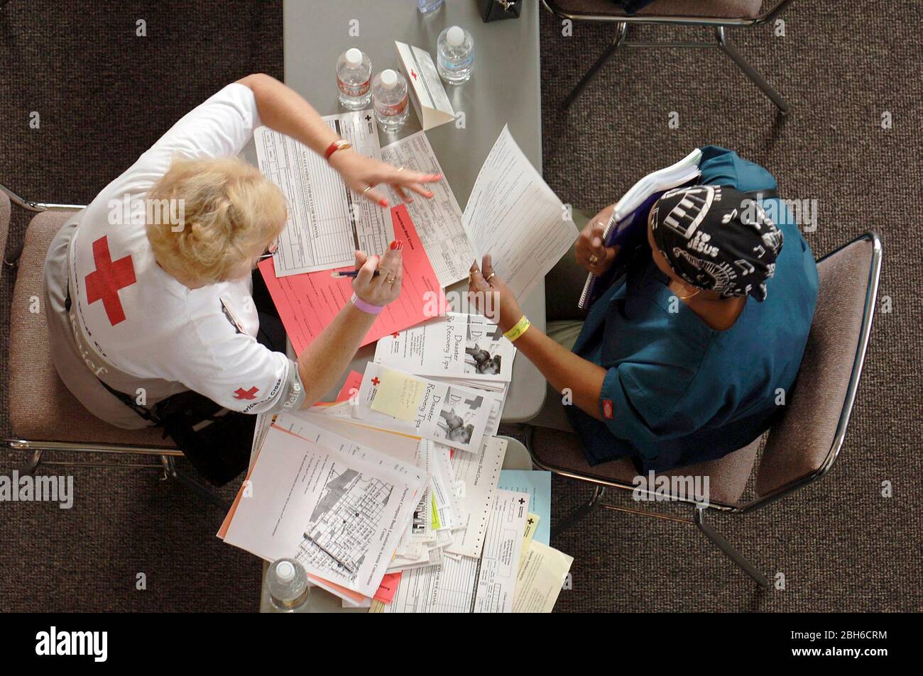 Austin, Texas USA, 10 settembre 2005: Il volontario della Croce Rossa assiste la vittima dell'uragano Katrina evacuata nel sito di soccorso dell'Austin Convention Center 12 giorni dopo l'arrivo della tempesta sulla costa del Golfo. ©Bob Daemmrich Foto Stock