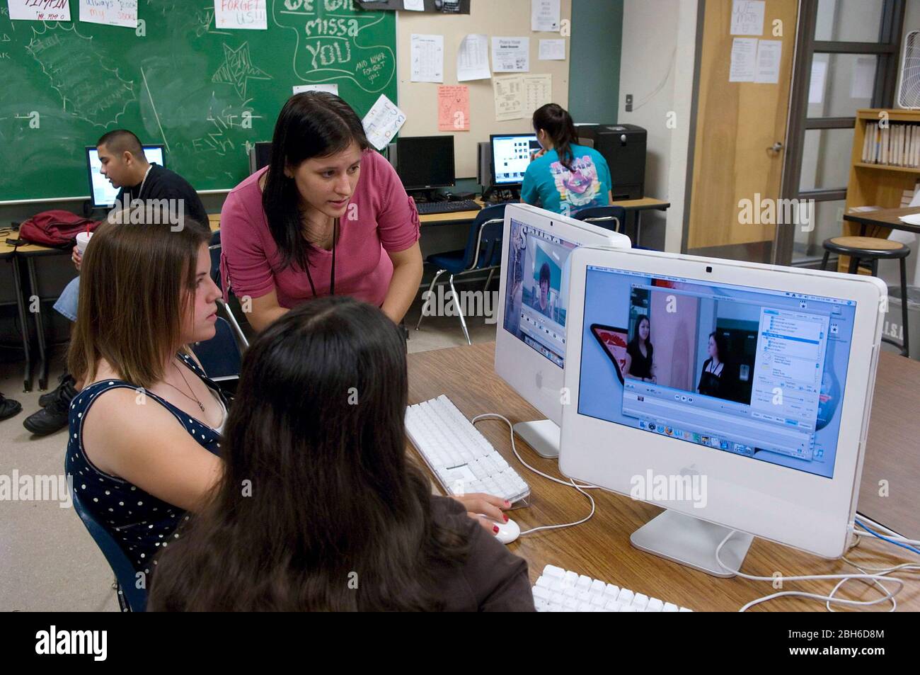 Austin, Texas USA, 18 maggio 2007: L'insegnante guarda gli studenti di nona classe che montano video digitali su un iMac Apple con due monitor alla Akins High School. ©Bob Daemmrich Foto Stock