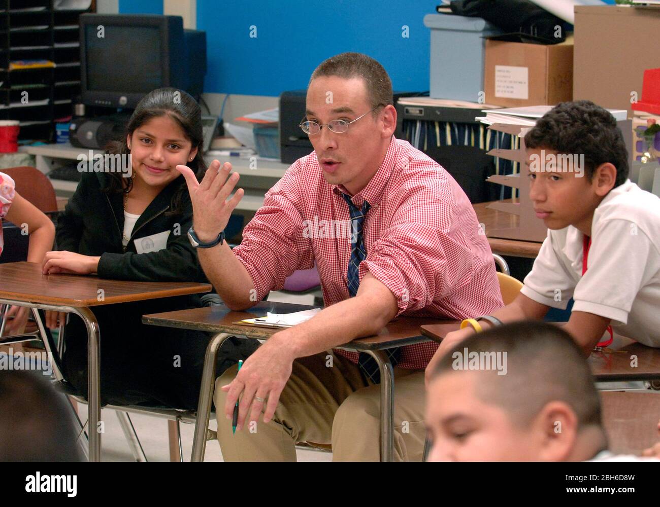 San Antonio, Texas USA, 19 ottobre 2006. Consigliere che parla di problemi familiari con gli studenti della scuola media durante la sessione post-scolastica in classe. Ciò fa parte di un programma dell'associazione di servizio della famiglia patrocinato dalla Fondazione di Annie E. Casey per contribuire ad aumentare il coinvolgimento dei genitori l'annuncio offre l'aiuto di lavoro e la consulenza per gli allievi della scuola media urbana. ©Bob Daemmrich Foto Stock San Antonio, Texas USA, 19 ottobre 2006. Consigliere che parla di problemi familiari con gli studenti della scuola media durante la sessione post-scolastica in classe. Ciò fa parte di un programma dell'associazione di servizio della famiglia patrocinato dalla Fondazione di Annie E. Casey per contribuire ad aumentare il coinvolgimento dei genitori l'annuncio offre l'aiuto di lavoro e la consulenza per gli allievi della scuola media urbana. ©Bob Daemmrich Foto Stock