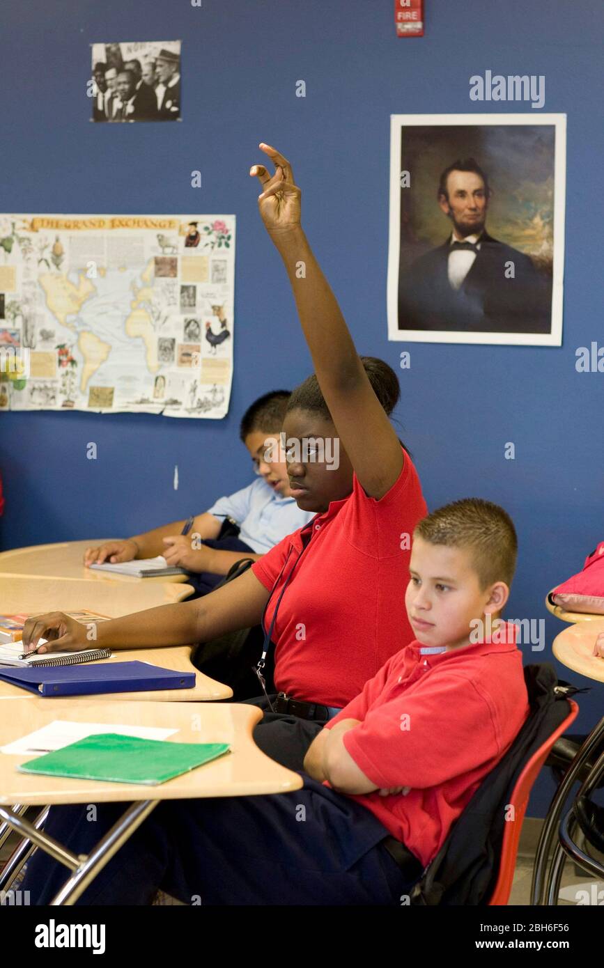 Dallas, Texas, 23 gennaio 2009: La studentessa nera alza la mano nella settima classe di inglese al Peak Preparatory Academy di Dallas est. La ragazza sembra aver raggiunto la pubertà mentre i suoi compagni di classe maschi più piccoli non hanno. ©Bob Daemmrich Foto Stock