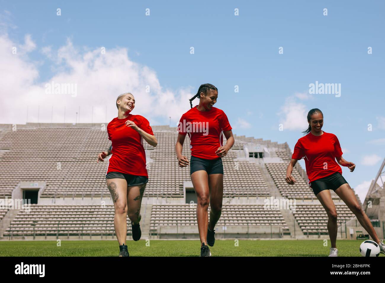 Gruppo di calciatori di calcio femminile allenarsi sul campo di calcio. Giovane donna calcio giocatori che pratica il controllo della palla durante la sessione di allenamento. Foto Stock
