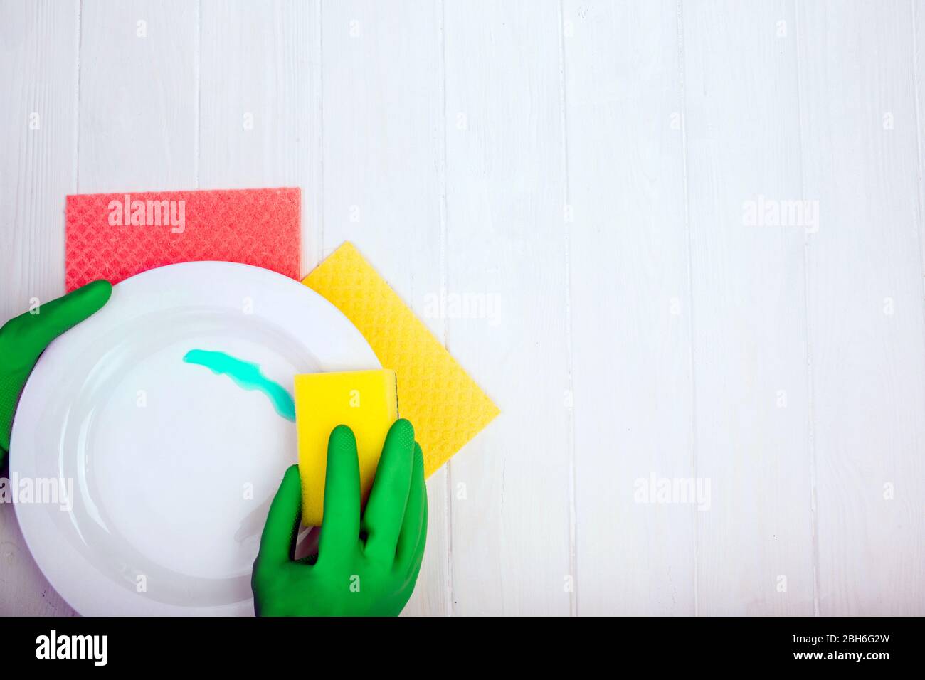 mani in guanti di gomma lavano piatti, vista dall'alto con spazio per le copie Foto Stock