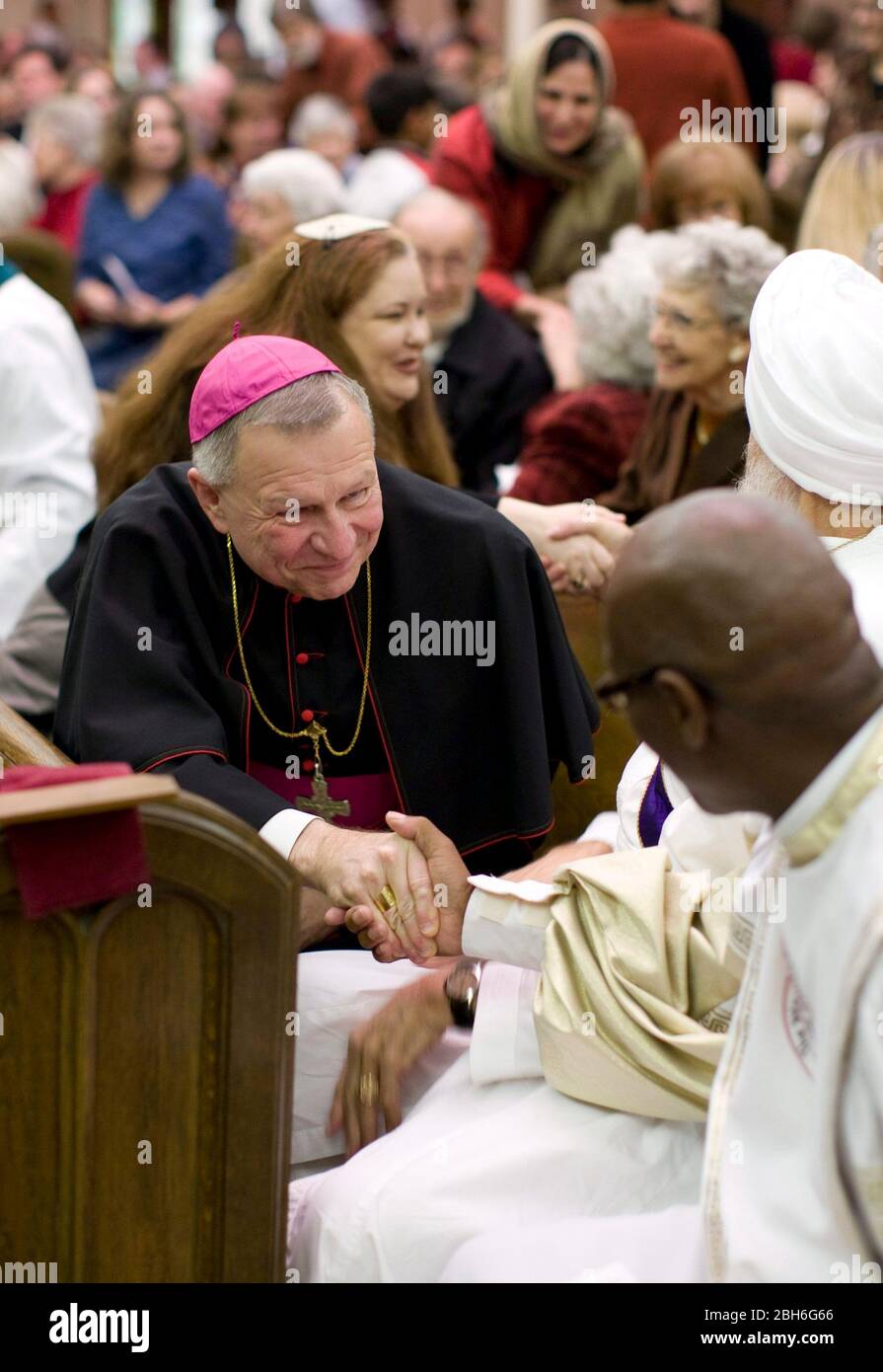 Austin, Texas: 23 novembre 2008. Austin Area Interreligiosi Ministries' (AAIM) 24th° anno InterFaith Thanksgiving celebrazione della diversità mostrando il Vescovo cattolico Gregory Aymond scuotere le mani con altri celebranti. ©Bob Daemmrich Foto Stock