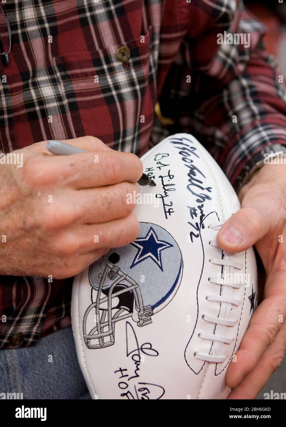 Austin, Texas USA, 21 novembre 2008: Leggendaria Dallas Cowboy Defensive Tackle Bob Lilly usa una penna Sharpie per autografare un calcio commemorativo in un libro che firma per il suo nuovo libro, 'A Cowboy's Life'. La carriera di Lilly nel 14 nella NFL dal 1961 al 1974 è stata evidenziata da sette selezioni All-Pro e da una vittoria Super Bowl nel 1972. ©Bob Daemmrich Foto Stock