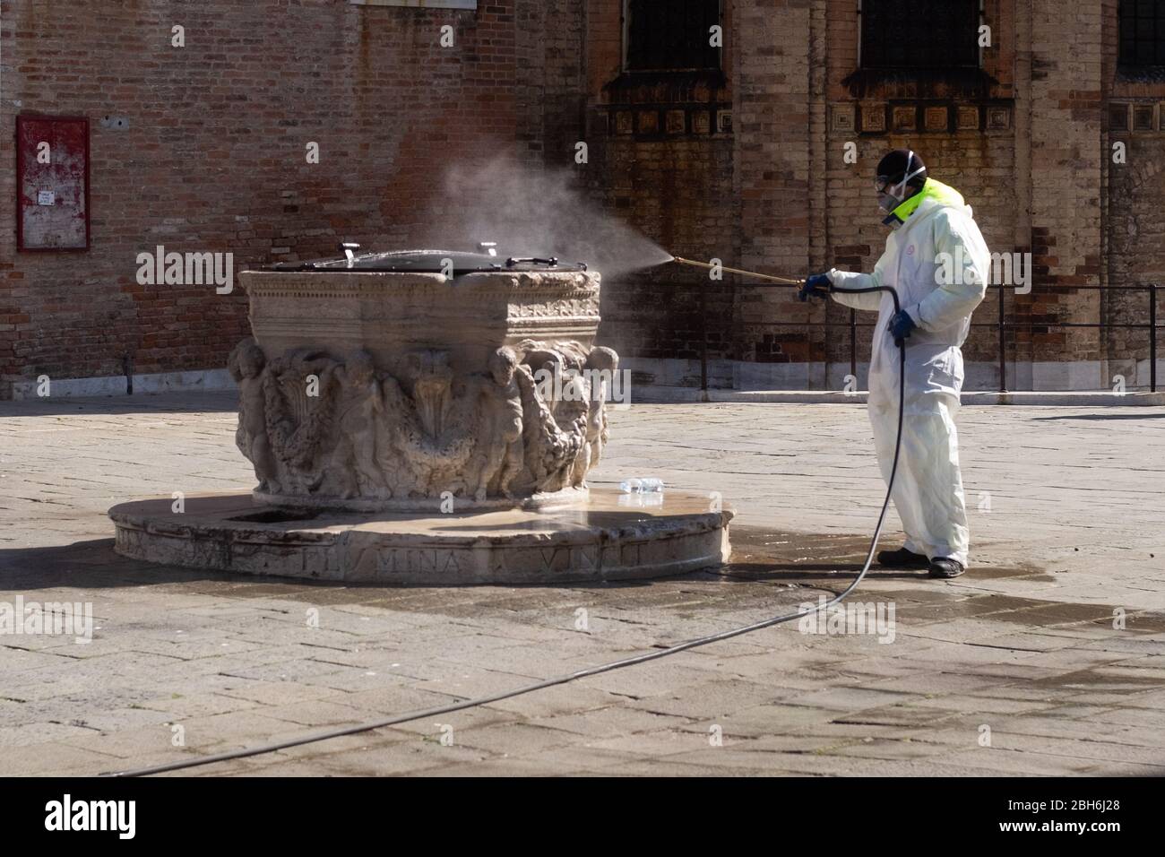 VENEZIA, ITALIA - APRILE 2020: Un operaio sanitizza bene di Venezia durante la chiusura nazionale per la pandemia Covid-19. Foto Stock