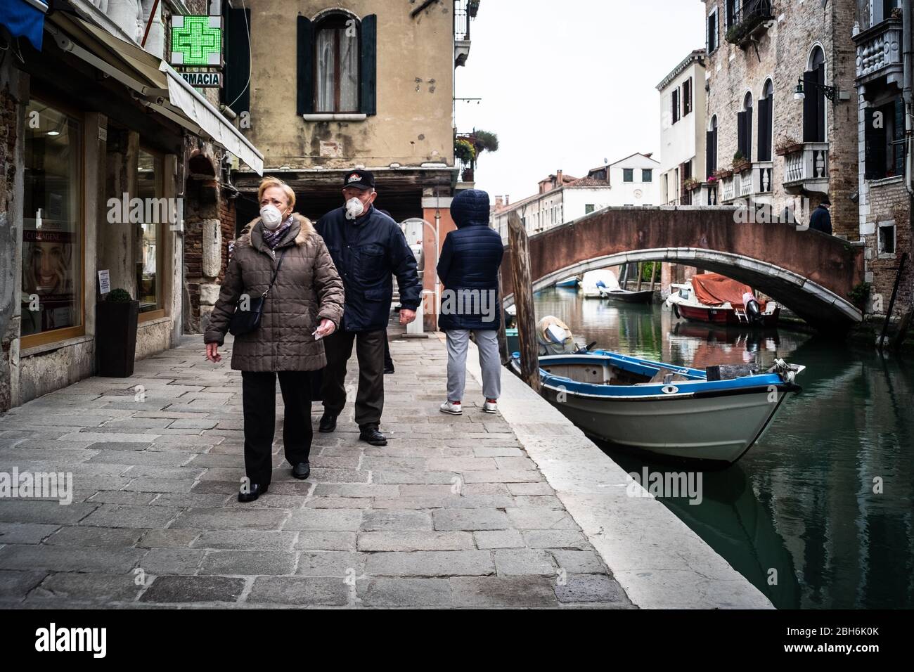 VENEZIA, ITALIA - APRILE 2020: Persone che indossano maschere protettive durante il periodo di chiusura nazionale per la pandemia Covid-19. Foto Stock