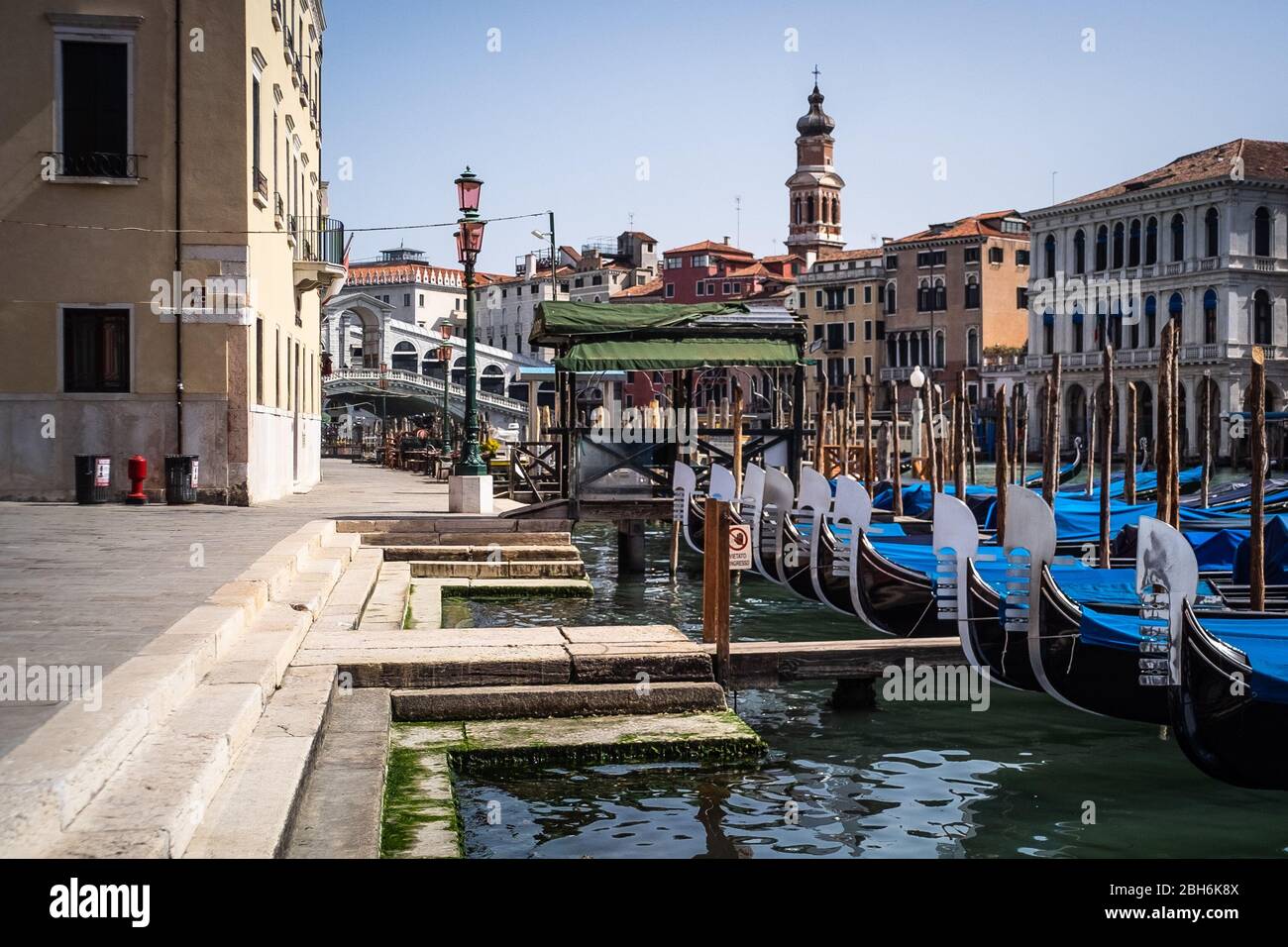 VENEZIA, ITALIA - APRILE 2020: Gondole ormeggiate accanto al ponte di Rialto durante la chiusura nazionale per la pandemia Covid-19. Foto Stock
