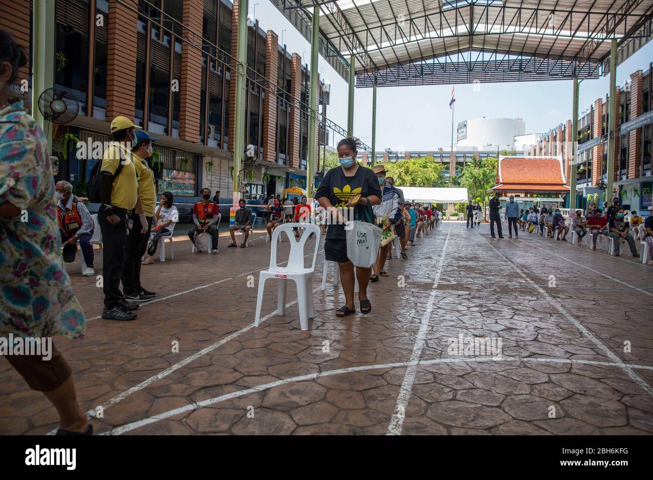 Bangkok, Thailandia. 24 Aprile 2020. La gente aspetta di ricevere pasti gratuiti per aiutare a combattere la perdita di reddito dovuta a COVID-19 alla Wat Don Muang School a Bangkok, Thailandia. 300 famiglie hanno accettato il cibo gratuito, con un'alimentazione stimata di 1500 persone sulla base della dimensione media della famiglia. Il cibo è stato agevolato dalla Thai Airforce per garantire adeguate misure di distanza sociale. Credit: Andre Malerba/ZUMA Wire/Alamy Live News Foto Stock
