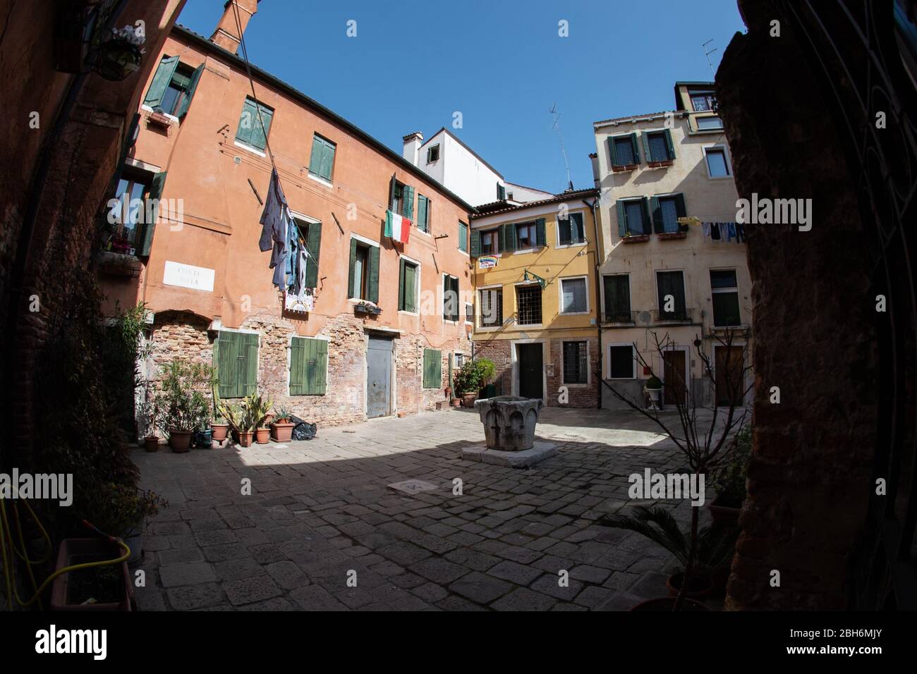 VENEZIA, ITALIA - APRILE 2020: Una piazza privata vuota con bandiera italiana durante il blocco nazionale per la pandemia Covid-19. Foto Stock