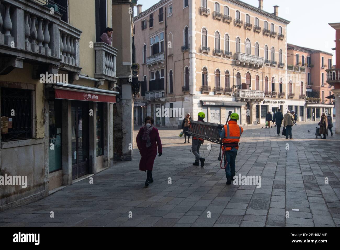 VENEZIA, ITALIA - APRILE 2020: La gente cammina in strade quasi vuote durante la chiusura nazionale per la pandemia di Covid-19. Foto Stock