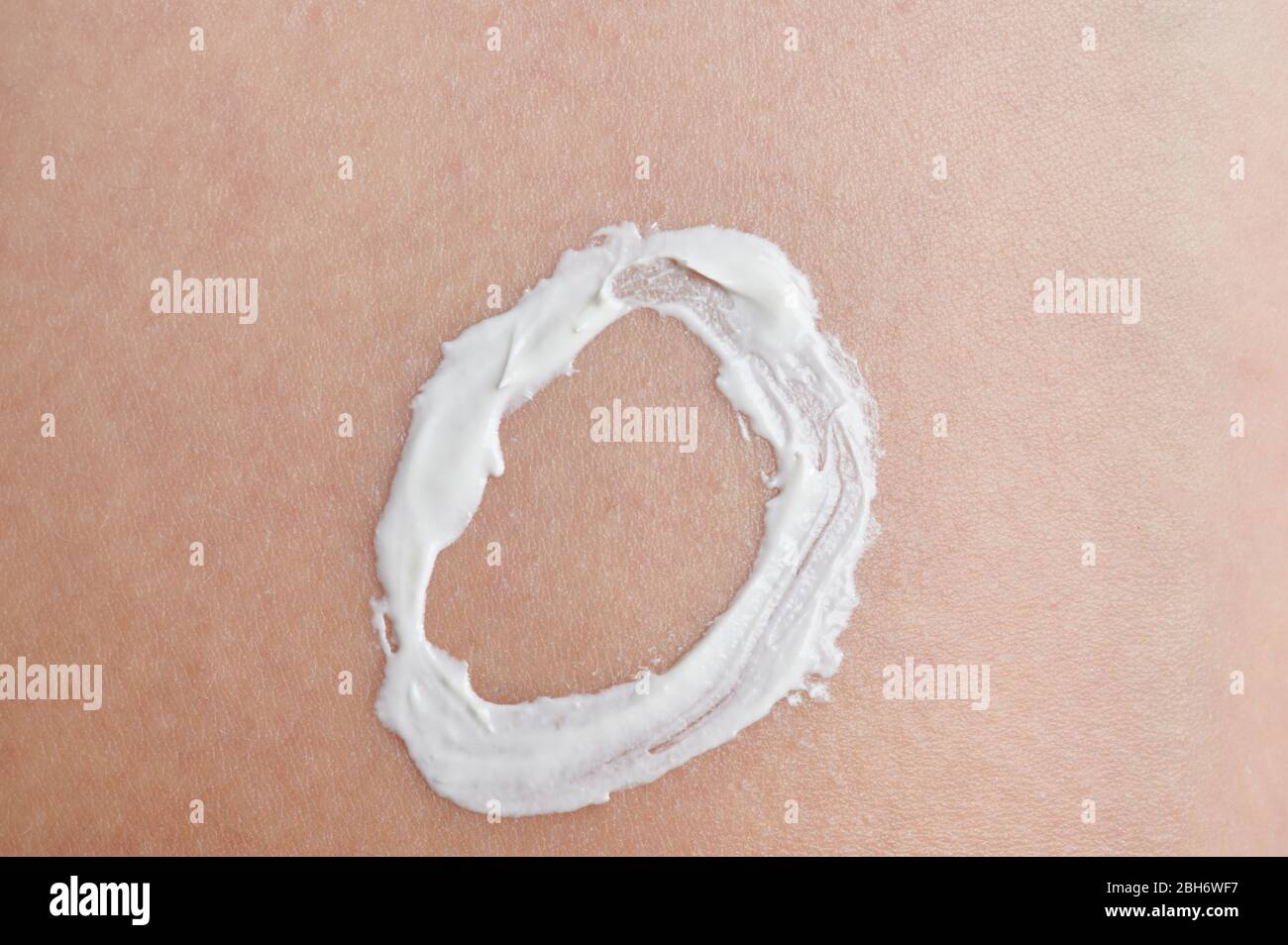 Tema di protezione della pelle del bambino. Forma circolare con crema per pelle bianca Foto Stock