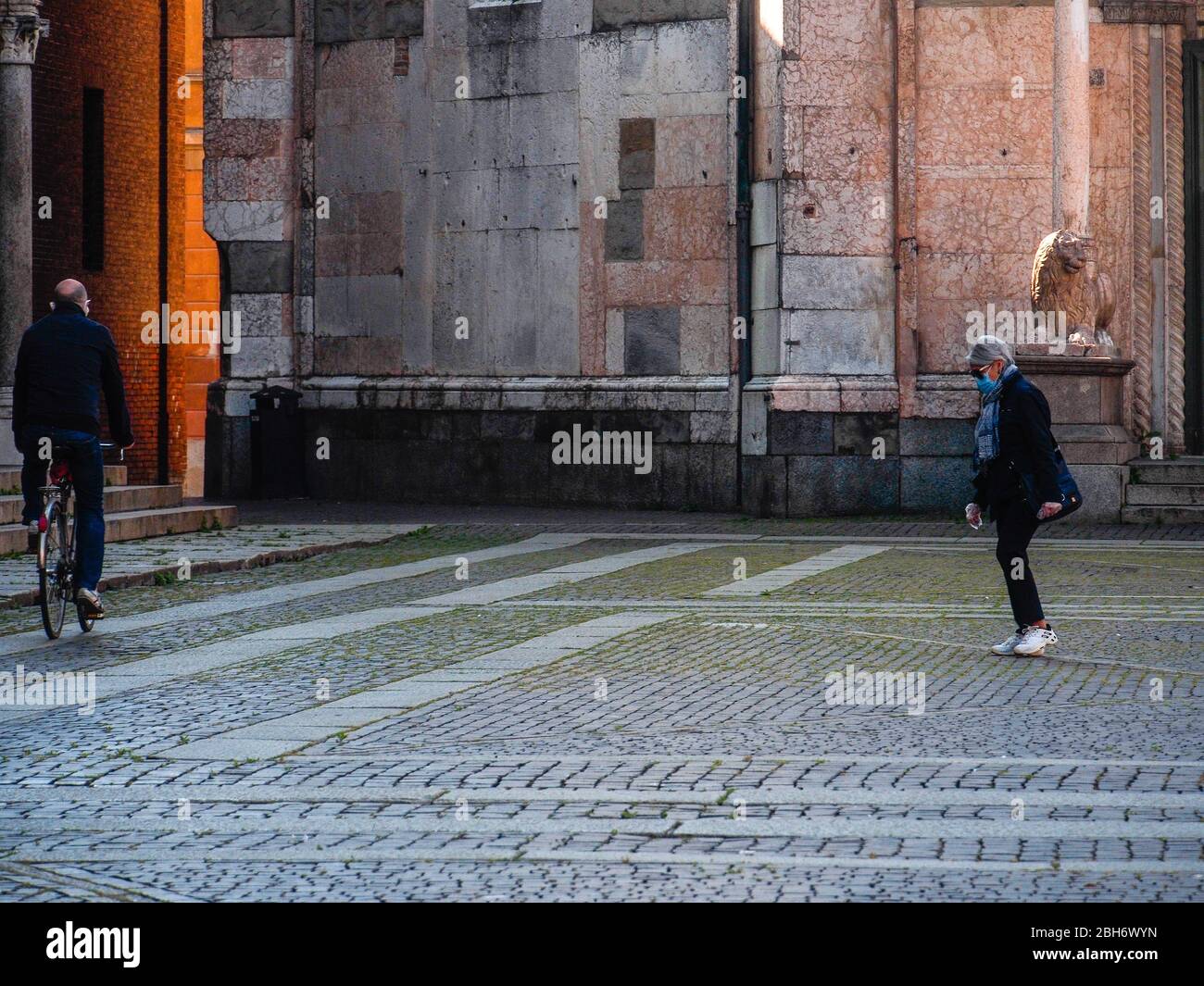 Cremona, Lombardia, Italia - 24 Aprile 20 2020 - persone a piedi, in bicicletta e in dogwalking in centro, vita quotidiana della città durante il coronavirus città di blocco Foto Stock