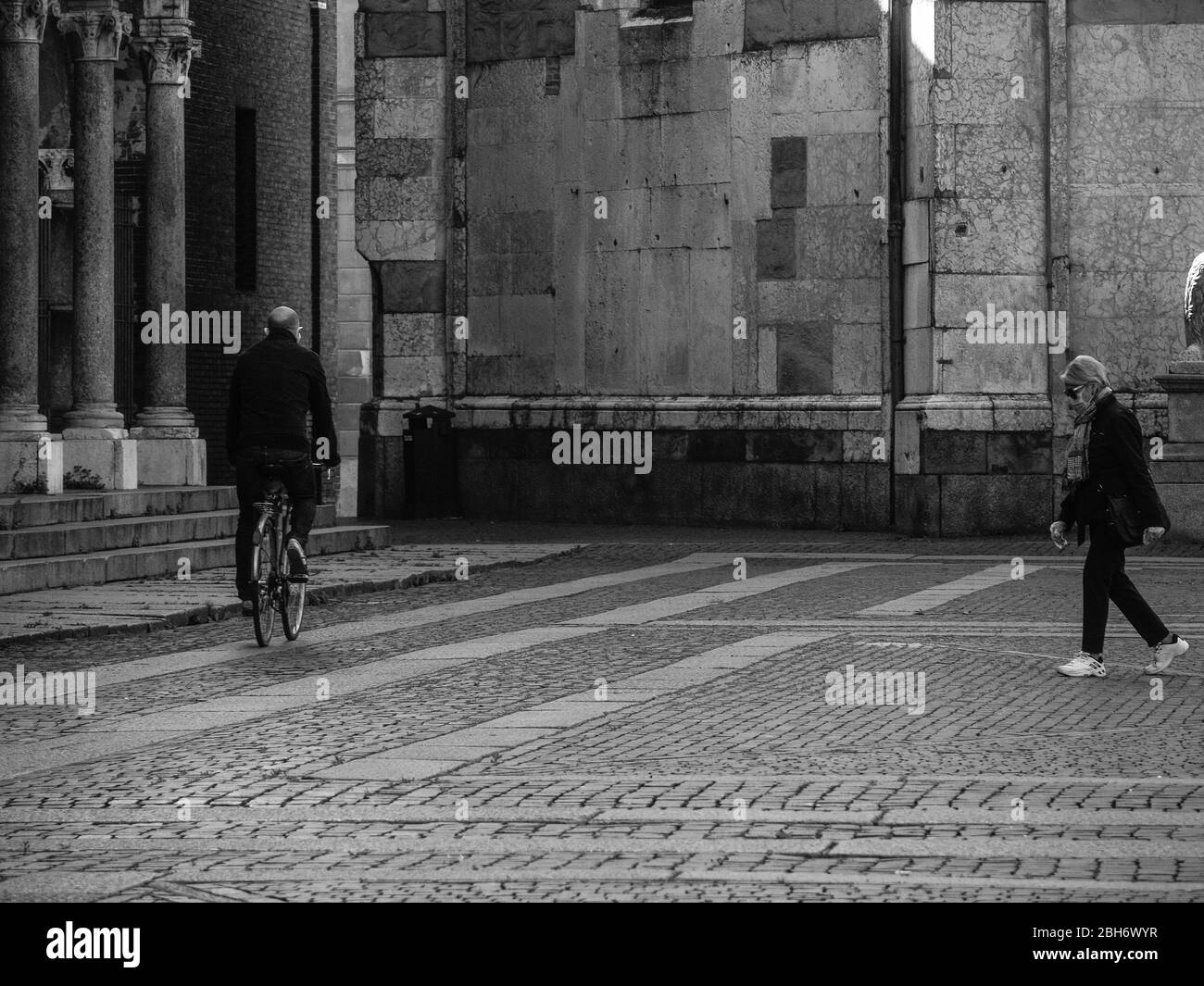Cremona, Lombardia, Italia - 24 Aprile 20 2020 - persone a piedi, in bicicletta e in dogwalking in centro, vita quotidiana della città durante il coronavirus città di blocco Foto Stock