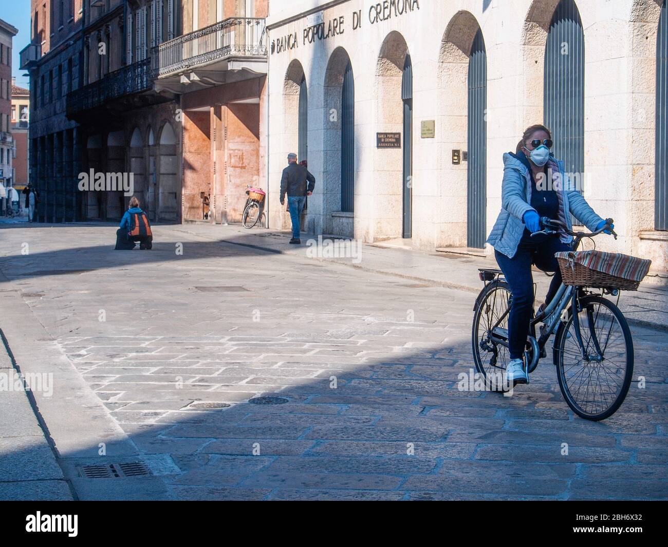Cremona, Lombardia, Italia - 24 Aprile 20 2020 - persone a piedi, in bicicletta e in dogwalking in centro, vita quotidiana della città durante il coronavirus città di blocco Foto Stock