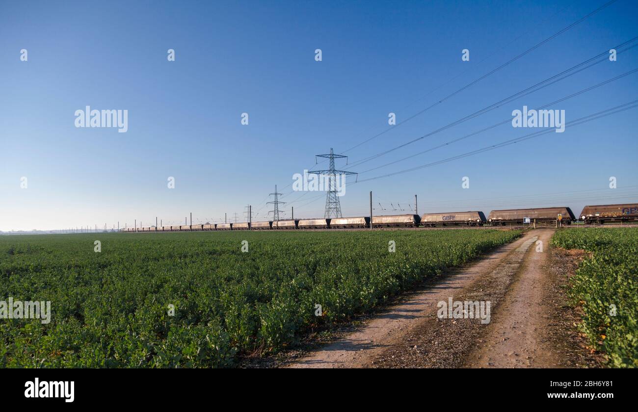GB Railspedifire Merry andare in giro treno trasporto di carbone importato per la generazione di elettricità sulla costa orientale mainline passando i tralicci elettrici Foto Stock