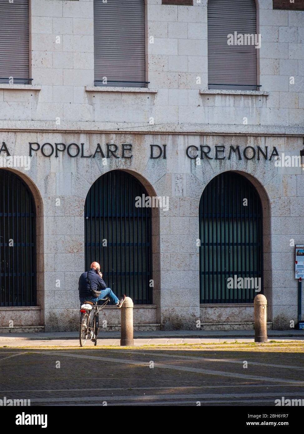 Cremona, Lombardia, Italia - 24 Aprile 20 2020 - persone a piedi, in bicicletta e in dogwalking in centro, vita quotidiana della città durante il coronavirus città di blocco Foto Stock