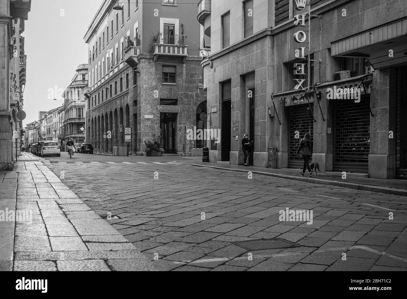 Cremona, Lombardia, Italia - 24 Aprile 20 2020 - persone a piedi, in bicicletta e in dogwalking in centro, vita quotidiana della città durante il coronavirus città di blocco Foto Stock