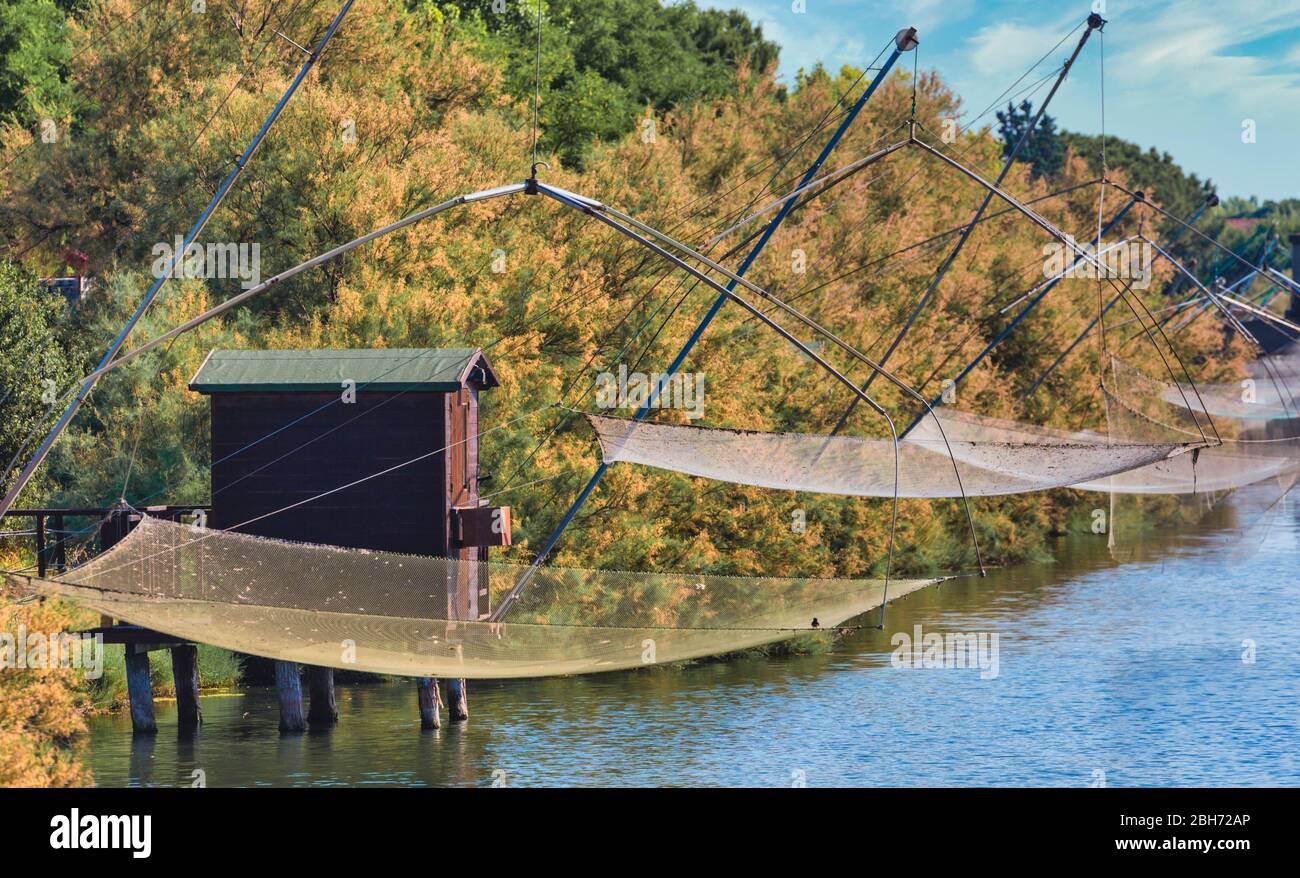 Cervia, Provincia di Ravenna, Italia. Capanna da pesca e reti da pesca sul canale di Cervia. Foto Stock