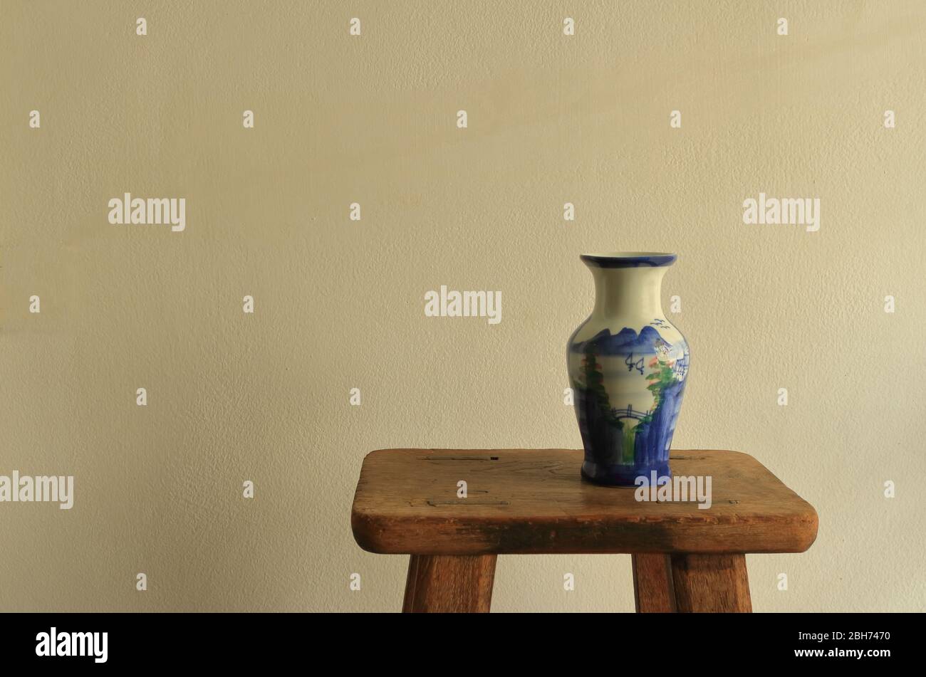 Vaso in ceramica vintage vuoto con pittura cinese paesaggio posto su sgabello di legno vintage, la pittura cinese è una delle più antiche arte del mondo conosciuto Foto Stock