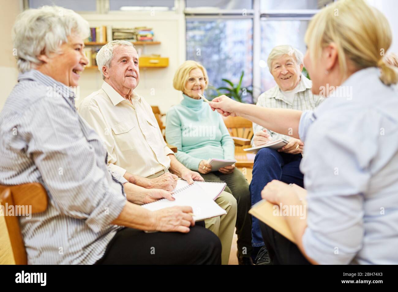 Psicoterapeuta e anziani con terapia di gruppo in una casa di riposo Foto Stock