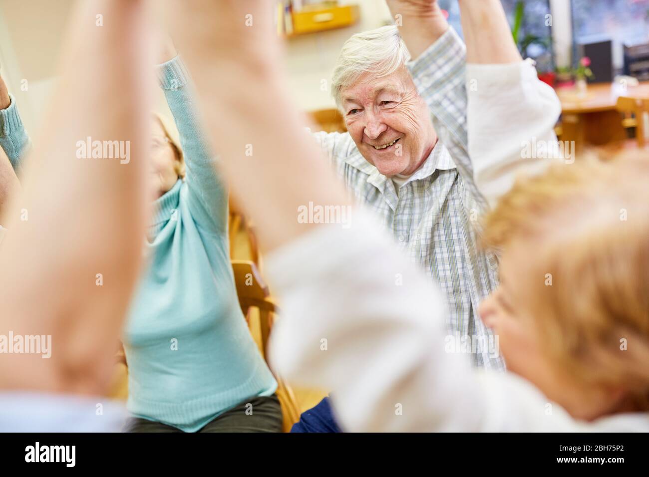 Gli anziani tengono le mani durante un gioco di interazione e di comunità Foto Stock