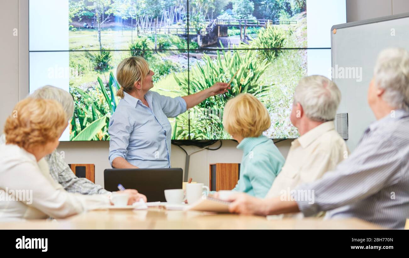 Gruppo di anziani e relatori in un seminario sulla protezione ambientale presso il centro di educazione per adulti Foto Stock