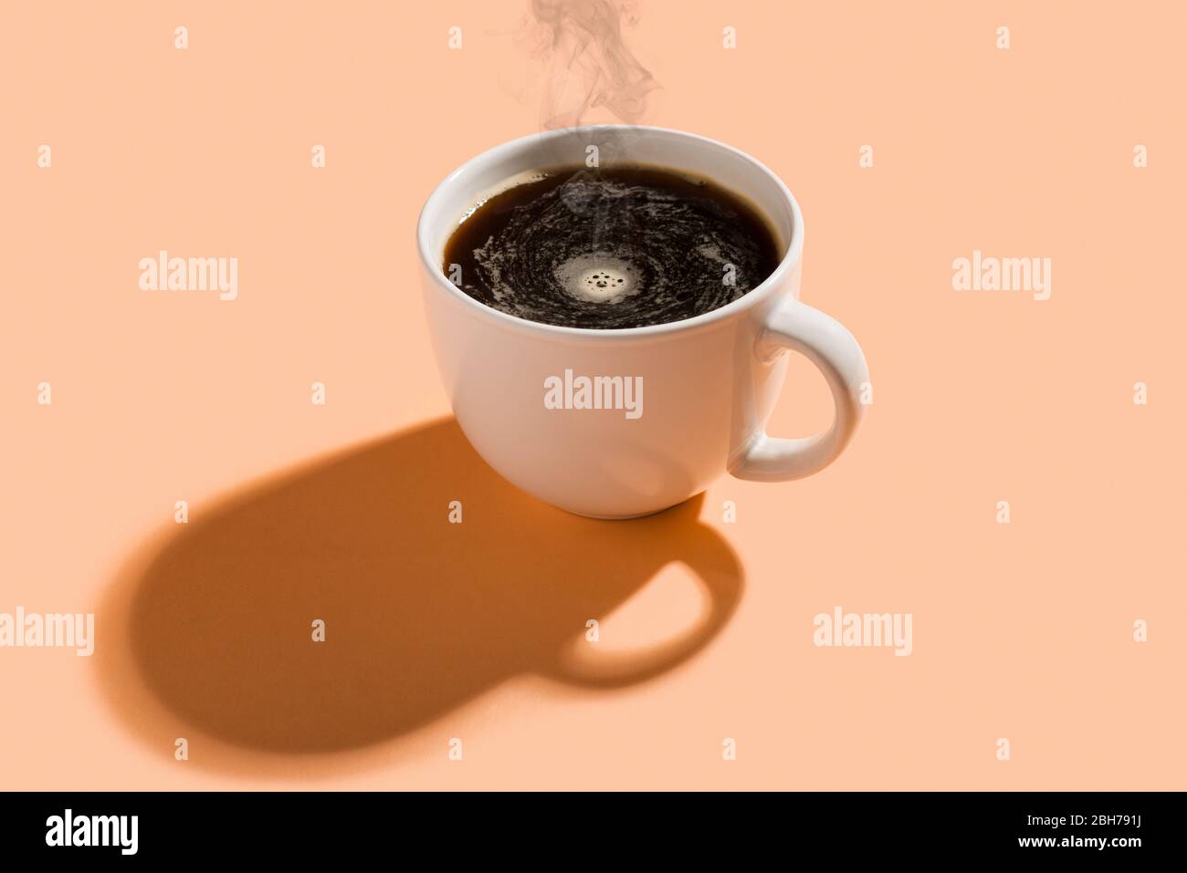Una tazza di caffè caldo con vapore su sfondo colorato. Foto Stock