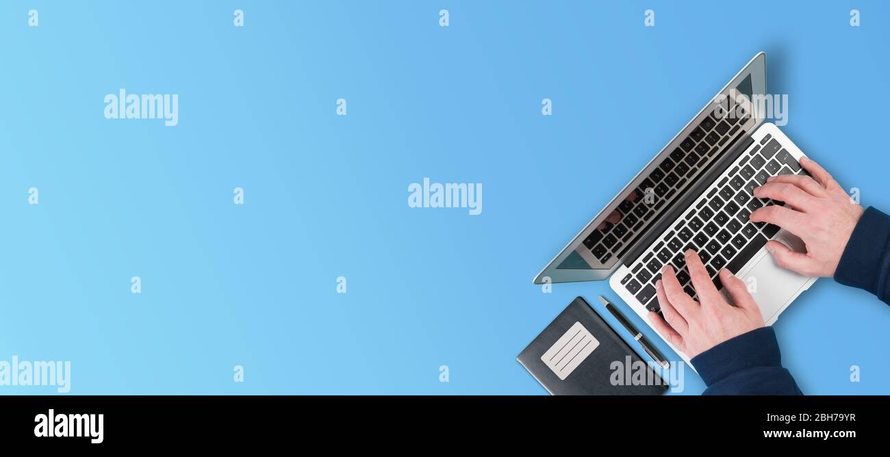 vista sopra della persona che utilizza il computer portatile su sfondo blu Foto Stock