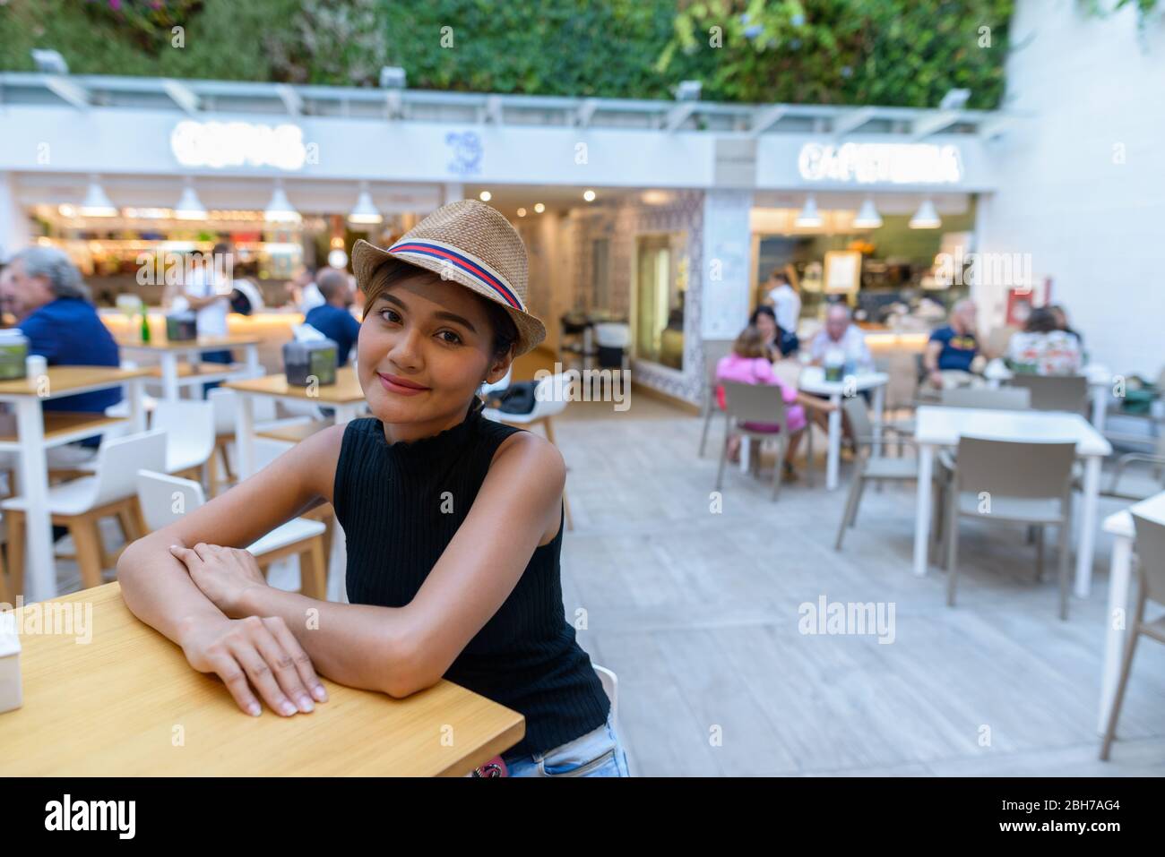 Giovane bella donna turistica asiatica seduta al ristorante all'aperto Foto Stock