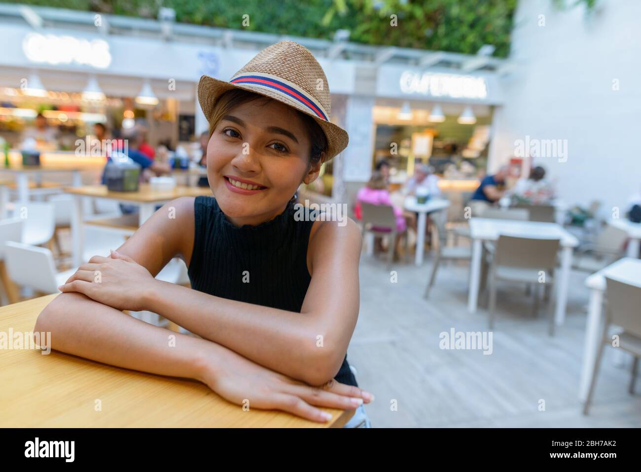 Felice giovane turista asiatico sorridente al ristorante all'aperto Foto Stock