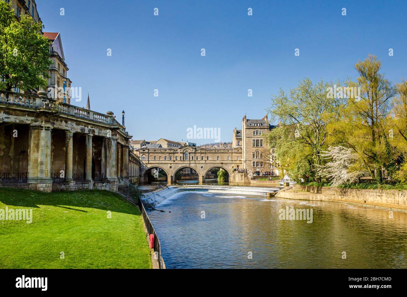 Paesaggio del fiume Avon con Pulteney Bridge e lo stramazzo nella città di Bath, Somerset, Regno Unito in una chiara e soleggiata Primavera mattina Foto Stock