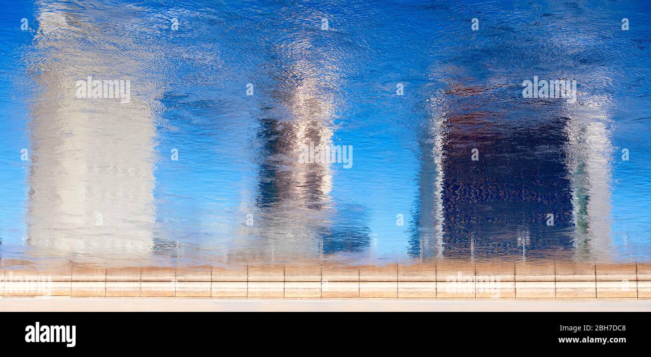 Sfocata riflessione silhouette di edifici su un'acqua al sole bella giornata, tono luminoso.artistico sfondo urbano Foto Stock