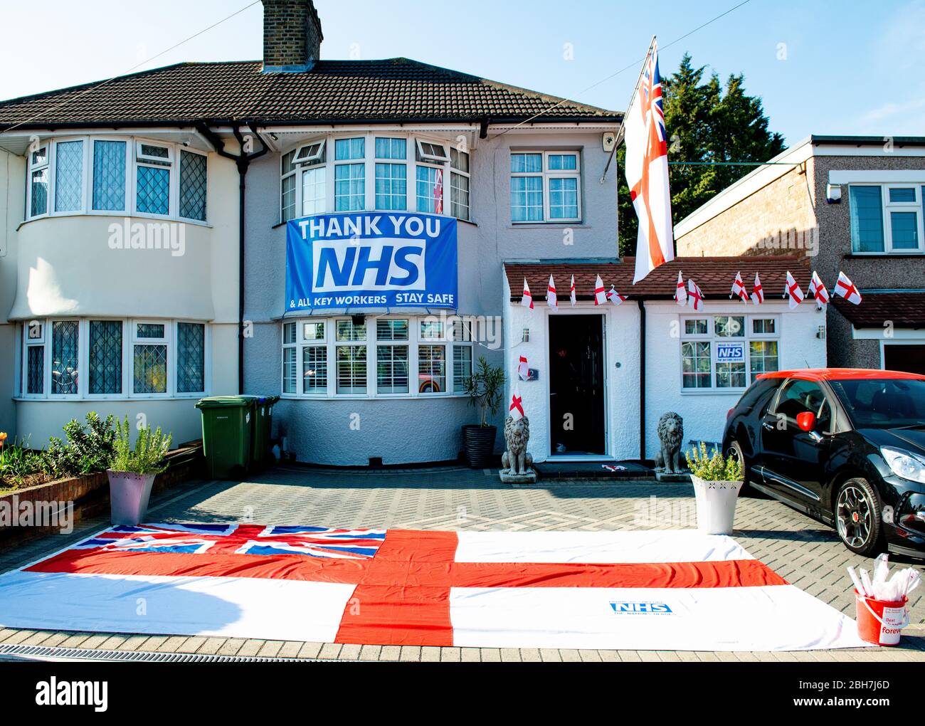 Grande bandiera e bandiera di fronte a casa ringraziando il NHS e tutti i principali lavoratori nel Regno Unito, durante la crisi pandemica di Covid-19/Coronavirus. Foto Stock