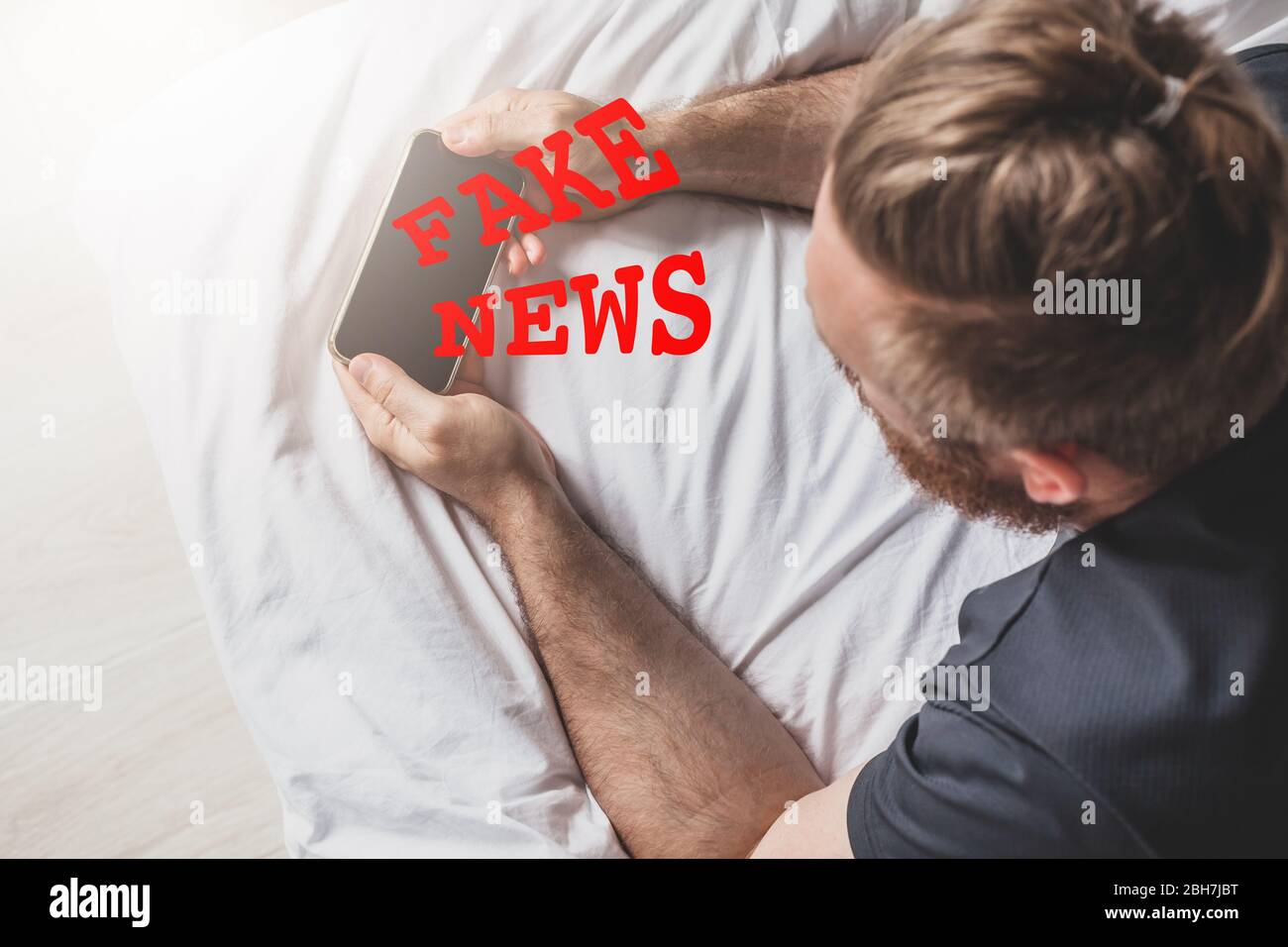 Infodemiche notizie false durante il concetto pandemico Covid-19. Uomo mani che tengono il telefono cellulare a leggere notizie globali o social network a casa. Lettura ultime notizie upd Foto Stock