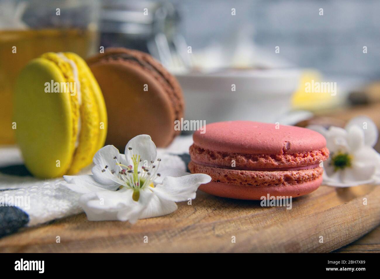 Una tazza di tè alla menta con biscotti macaron, su un asse di legno e finnick su tagliere di legno Foto Stock