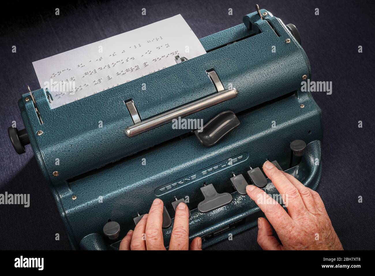 Una donna che batte in braille utilizzando una macchina da scrivere Perkins Brailler. Foto Stock