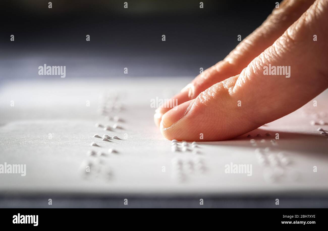 Un allievo della scuola adolescente che legge il testo braille con le sue dita Foto Stock