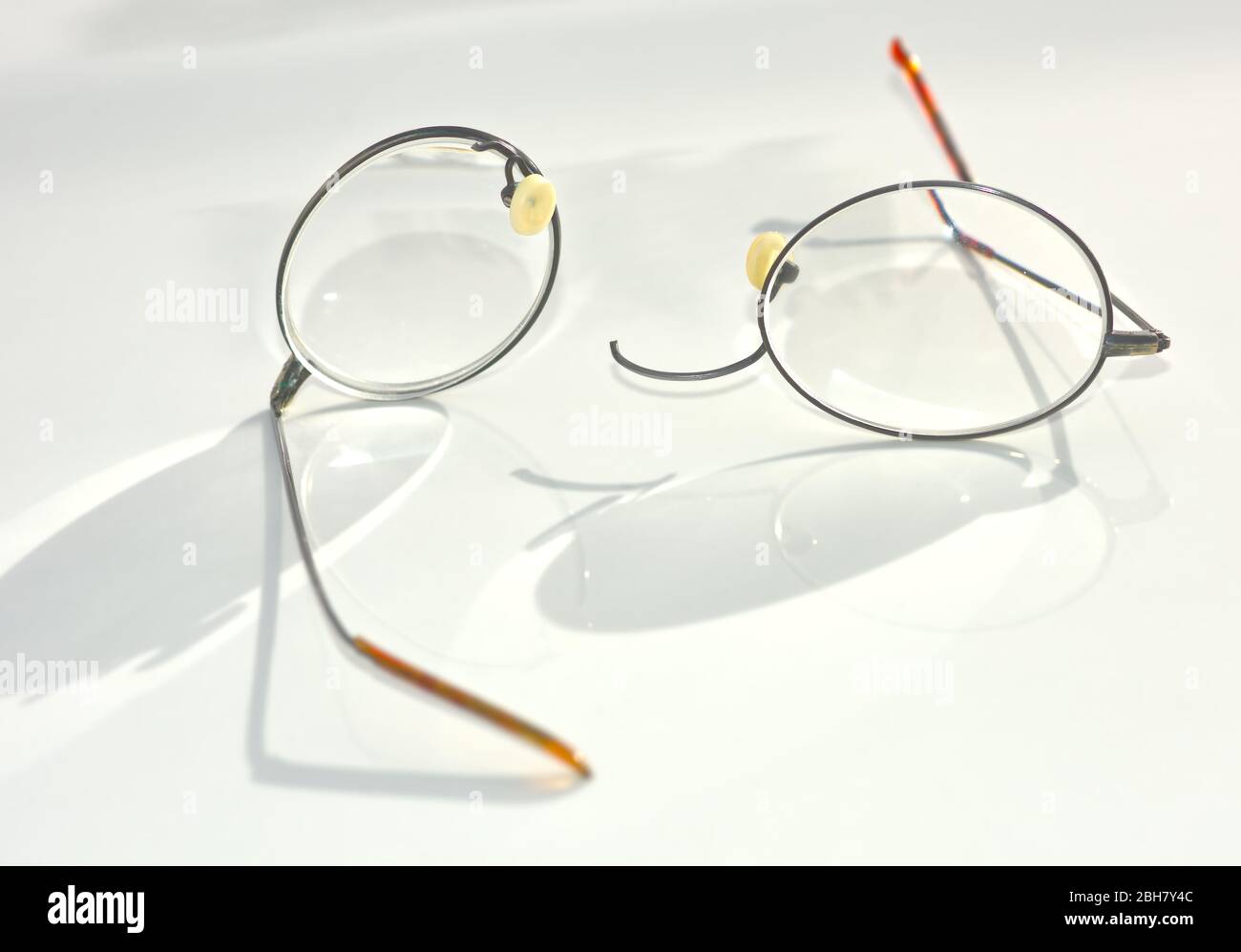 Un paio di occhiali con bordo in filo di titanio che si sono rotti e  separati sulla sezione del ponte nasale Foto stock - Alamy