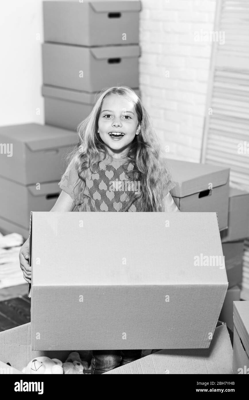 Concetto di uscita. Affitto casa. Casa di famiglia. Fornitura di servizi. Appartamento per famiglie. In uscita. Casella di gioco ragazza bambino. Prepararsi per il movimento. Imballaggi. Entusiasta di una nuova casa. Dolce casa. Foto Stock