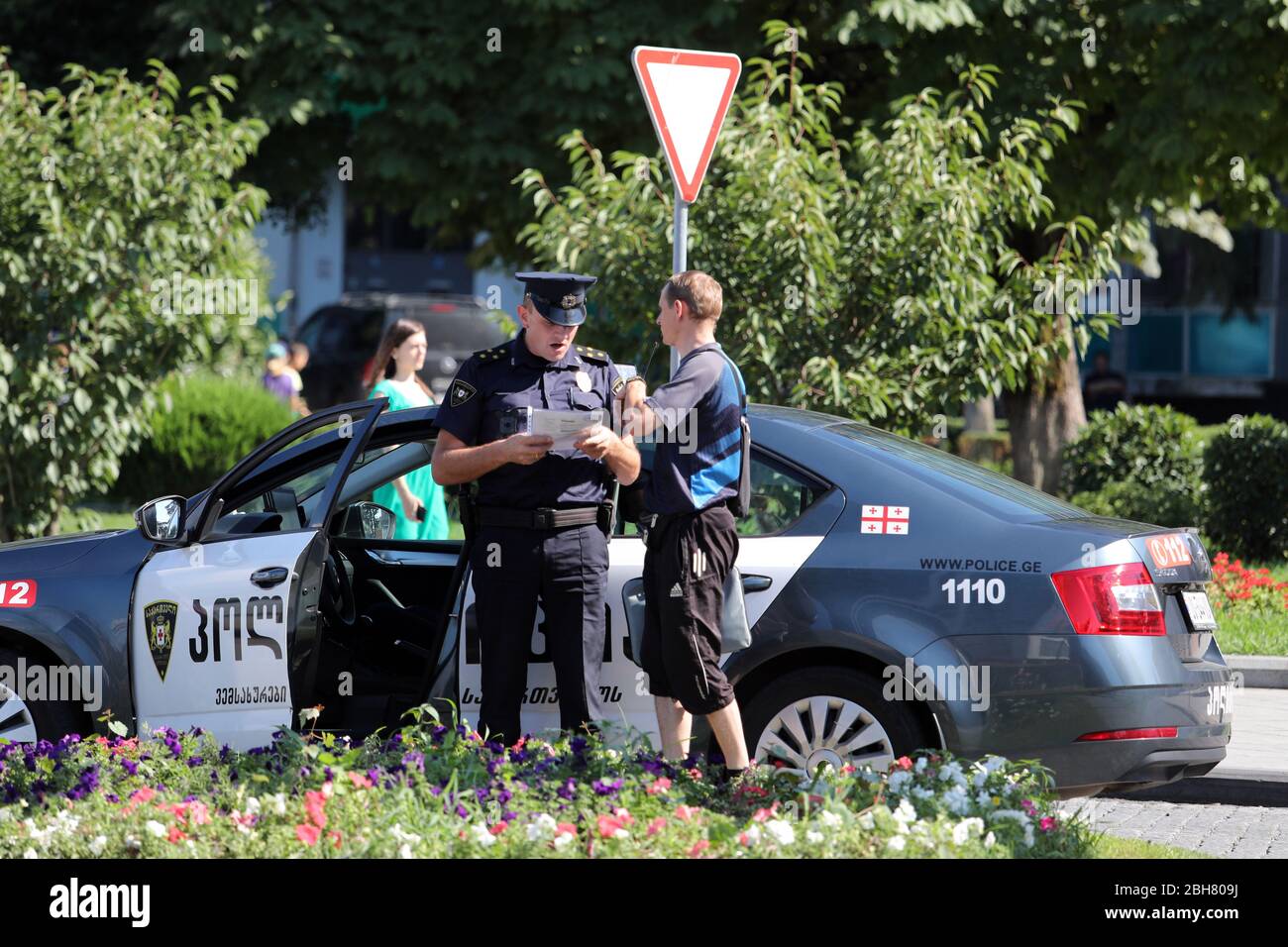 16.07.2018, Batumi, Adjaria, Georgia - poliziotto che parla con un uomo sul lato della strada. 00S180716D503CAROEX.JPG [VERSIONE MODELLO: SÌ, PROPRIETÀ Foto Stock