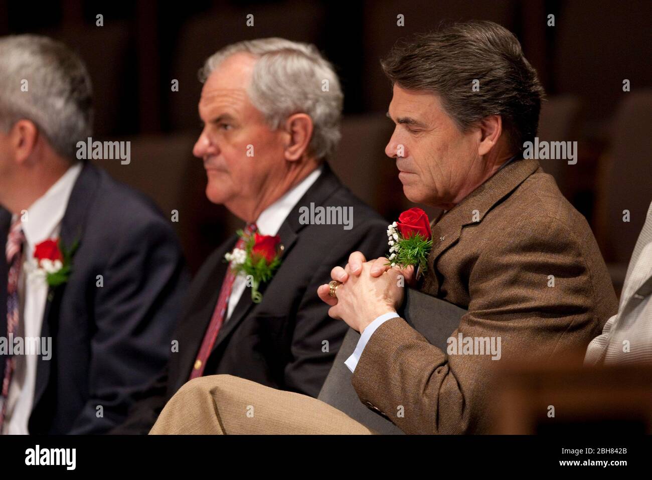 Killeen, Texas 8 novembre 2009: Il governatore del Texas Rick Perry (r) prega ad un servizio commemorativo presso la prima chiesa Battista di Killeen, tre giorni dopo l'accusato pistolero Nidal Hasan aperto il fuoco al vicino Fort Hood, uccidendo 13 persone e ferendo molti altri. ©Bob Daemmrich Foto Stock