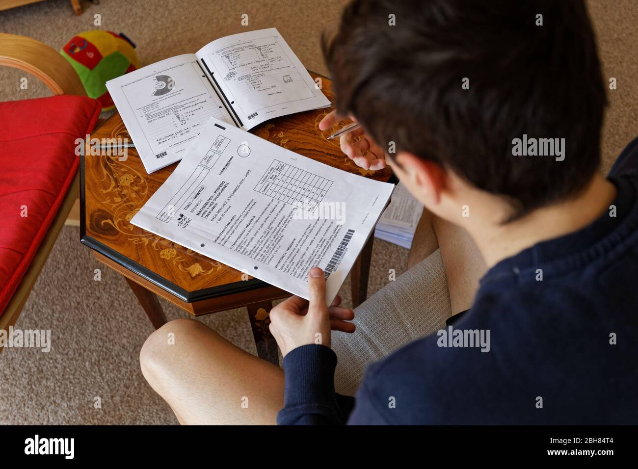 Nikolas Ioan, 15 anni, sta facendo i compiti a casa sua mentre si isola con la sua famiglia durante la pandemia di Coronavirus Covid-19 Foto Stock
