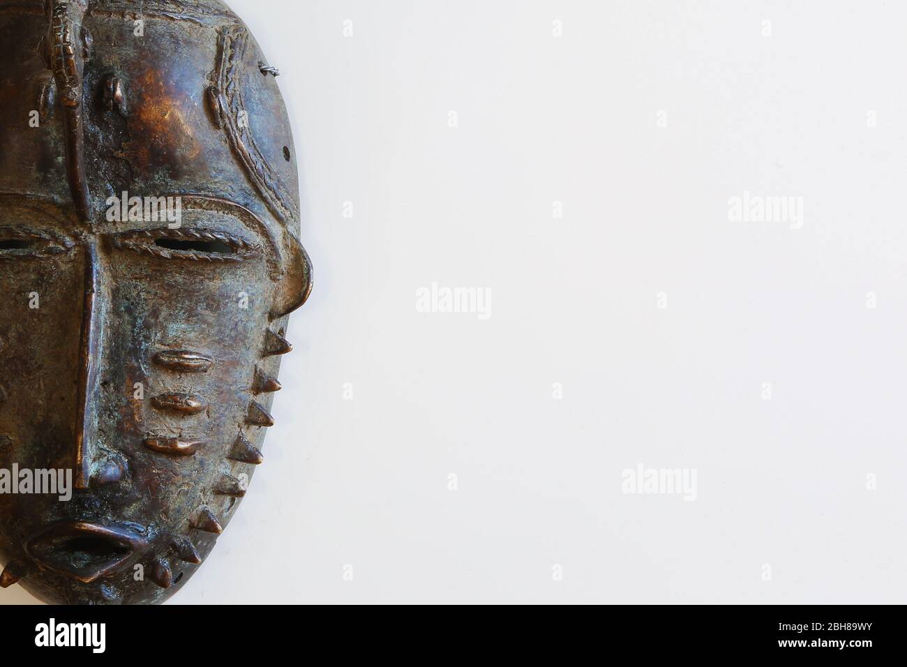 Maschera africana di ferro su sfondo bianco Foto Stock