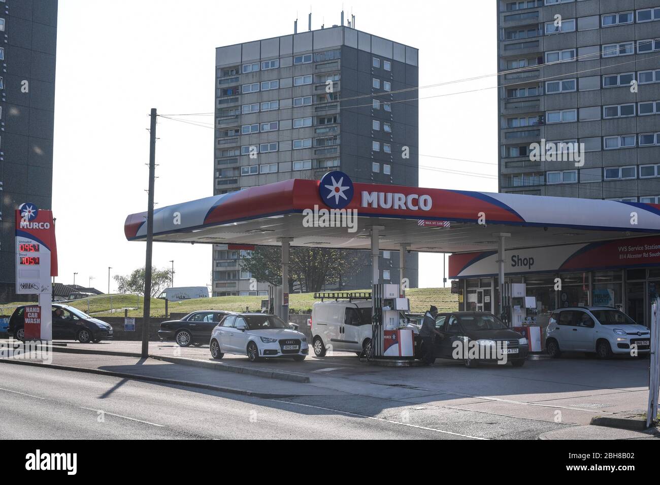 Maypole, Birmingham, West Midlands, Regno Unito. 24 aprile 2020. Una stazione di servizio Murco, definita "la più economica d'Inghilterra", vende benzina senza piombo a soli 95,7 pence al litro. I prezzi bassissimi presso la stazione di servizio di Alcester Road South sono dovuti al calo dei prezzi del petrolio negli Stati Uniti al di sotto dello zero e al calo mensile delle vendite di benzina nel Regno Unito del 18,9%. I clienti hanno fatto la fila per ottenere il carburante dell'affare, poiché il blocco COVID-19 ha colpito duramente i guadagni per molte famiglie. Credito: Interrompi stampa Media/Alamy Live News Foto Stock