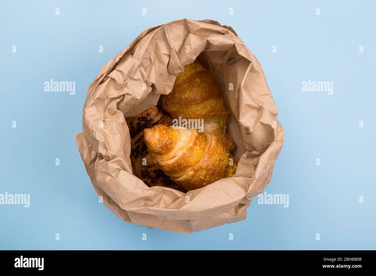 Colazione da gustare - croissant su sfondo blu. Consegna dei prodotti. Vista dall'alto Foto Stock