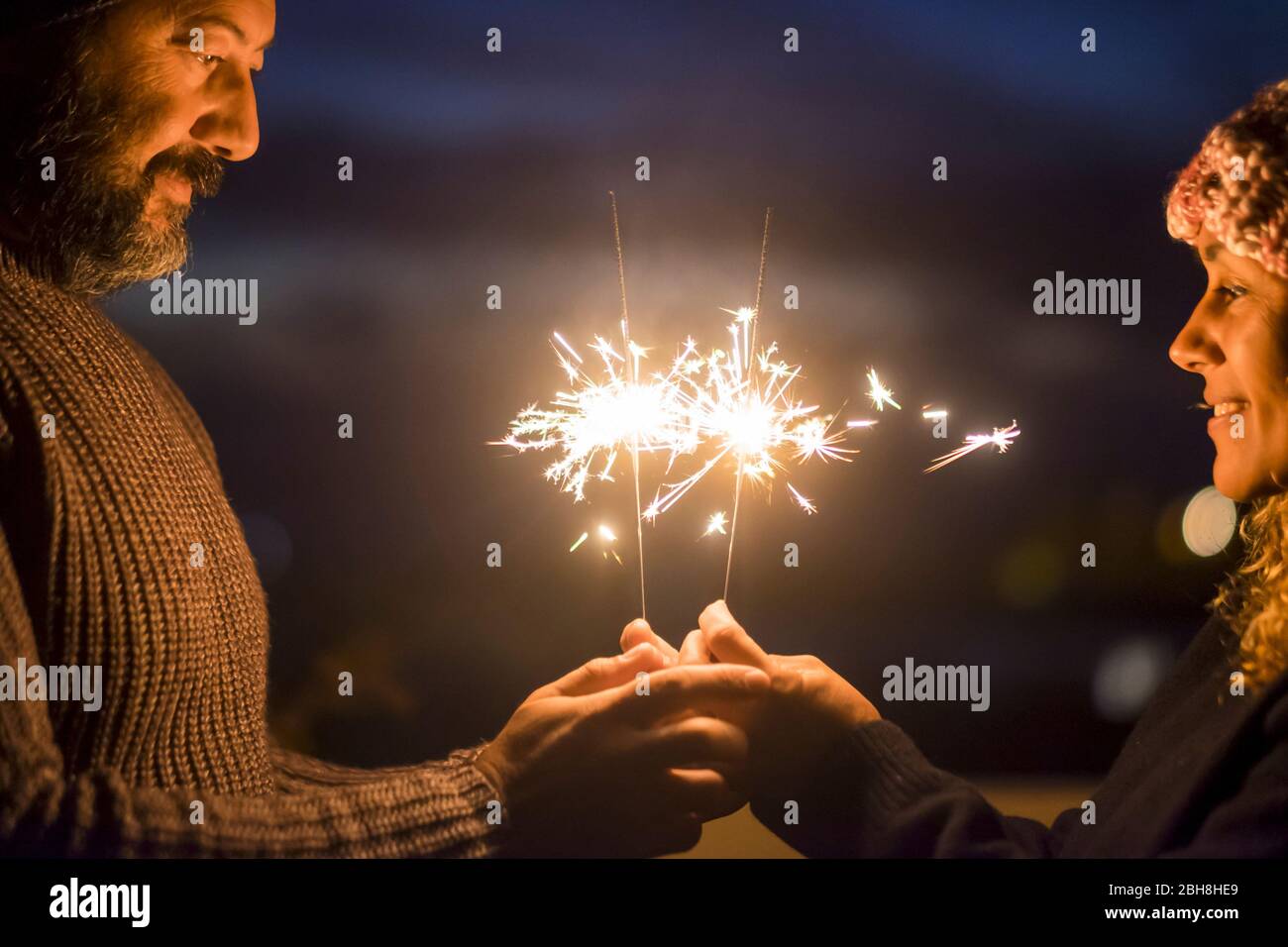 San Valentino e l'amore Concept celebrazione per caucasian media età bella coppia godere insieme stile di vita e la vita di insieme con scintille luce di notte - gente felice Foto Stock