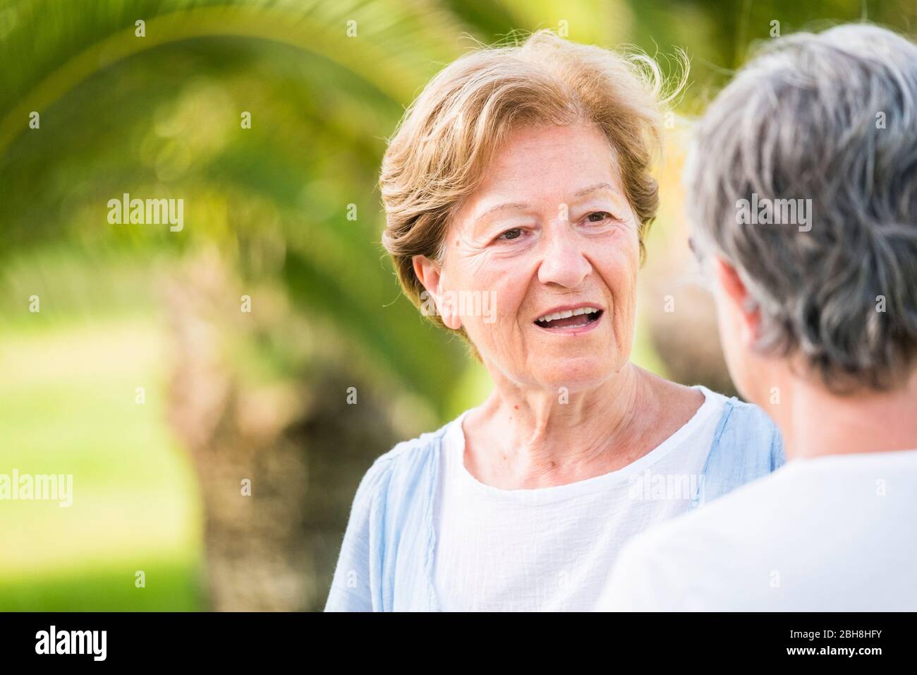 Coppia di anziani adulti donne amici parlare insieme in attività di svago all'aperto - stile di vita in pensione per la società d'argento e belle donne di età con 70 anni circa - sfondo verde bokeh Foto Stock