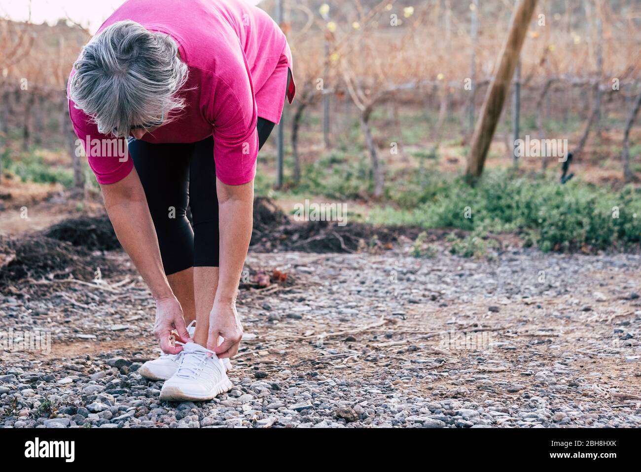 Adulto anziano gente caucasica donna che fa gli esercizi di corsa di idoneità all'aperto per rimanere sano e cura del hace dei loro corpi - concetto di stile di vita di sport e di benessere Foto Stock